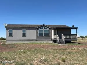 a view of a house with a yard and wooden fence