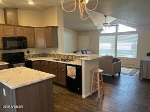 61 North 8620th Show Low, AZ 85901 - Photo 9 of 18 a kitchen with stainless steel appliances granite countertop a table chairs stove and microwave