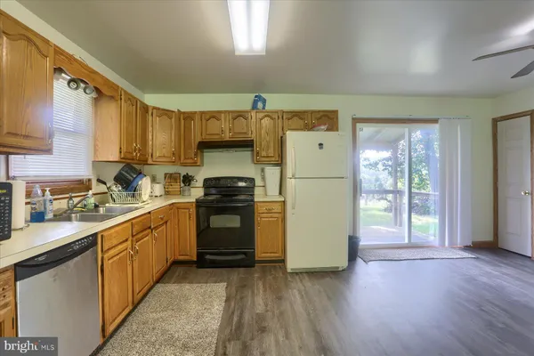 a large kitchen with lot of cabinets and wooden floor