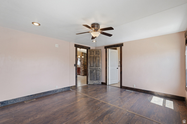 2875 North Hill Field Road, Unit 111 Layton, UT 84041 - Photo 13 of 30 Empty room featuring dark wood-type flooring, a ceiling fan, and hanging lights