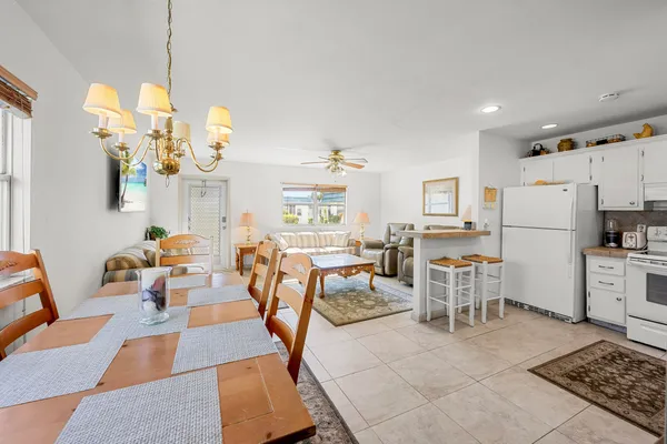 a living room with lots of white furniture and a table