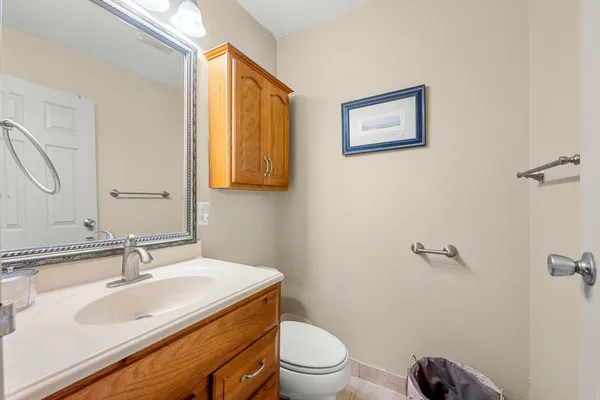 a bathroom with a granite countertop sink mirror vanity and toilet