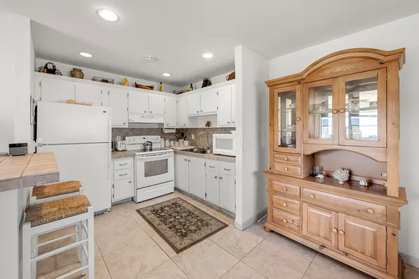 a kitchen with granite countertop cabinets and white appliances