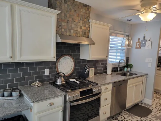 a bathroom with a granite countertop sink and a shower