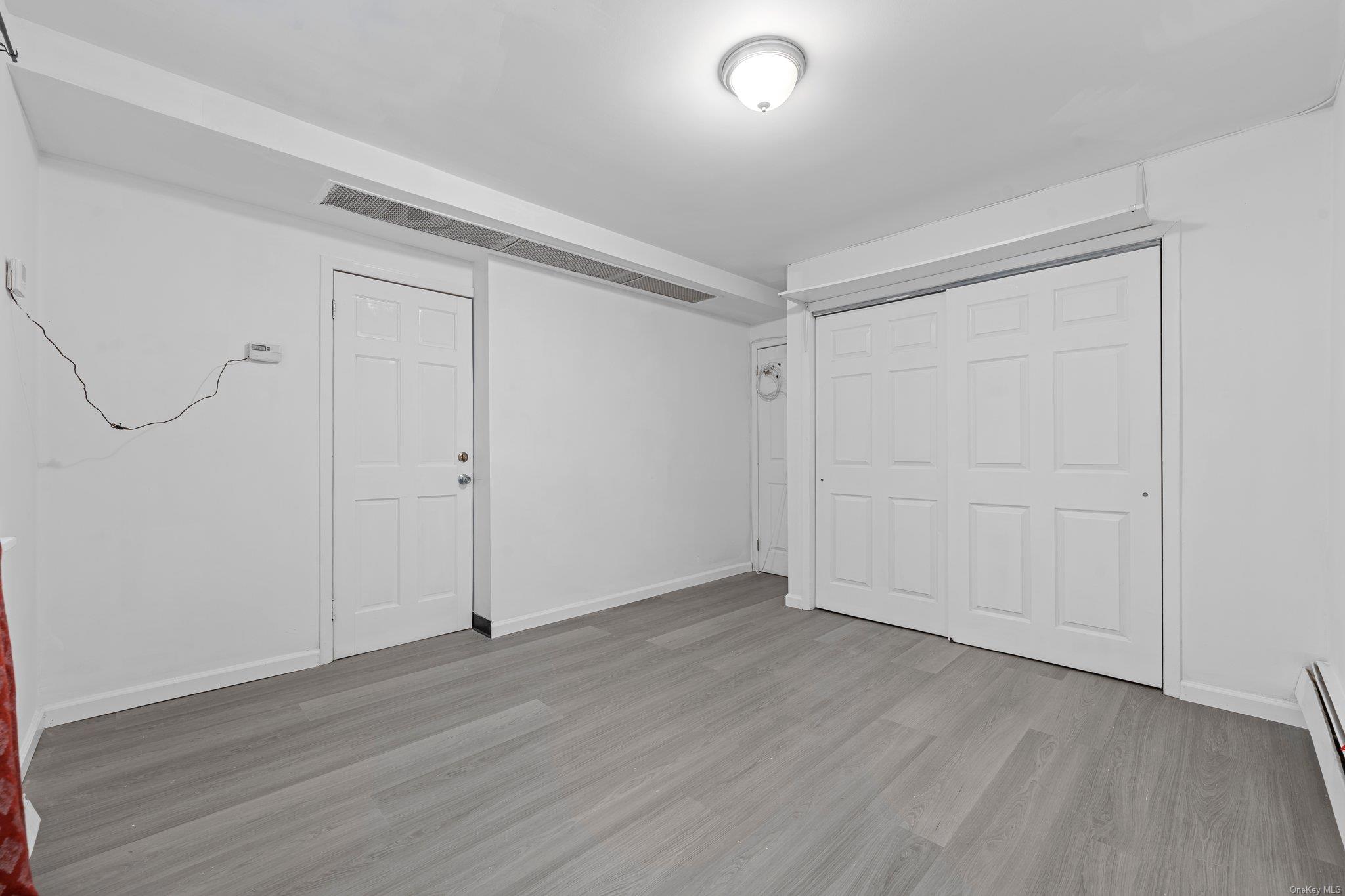 35-18 108th Street Queens, NY 11368 - Photo 5 of 20 Basement with light hardwood / wood-style floors and baseboard heating
