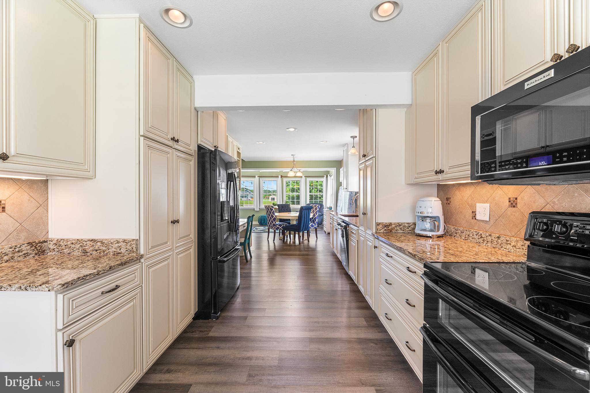 30249 Armory Road Dagsboro, DE 19939 - Photo 7 of 41 a kitchen with stainless steel appliances granite countertop a stove top oven a refrigerator a sink and dishwasher with wooden floor