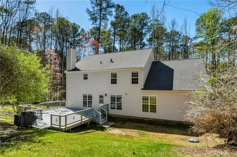 aerial view of a house with a yard and a large tree