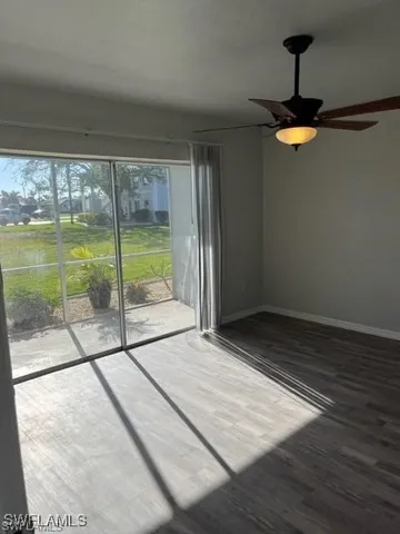 a view of an empty room with a floor to ceiling window and wooden floor