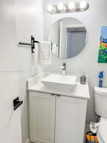 a bathroom with a toilet a sink and a mirror