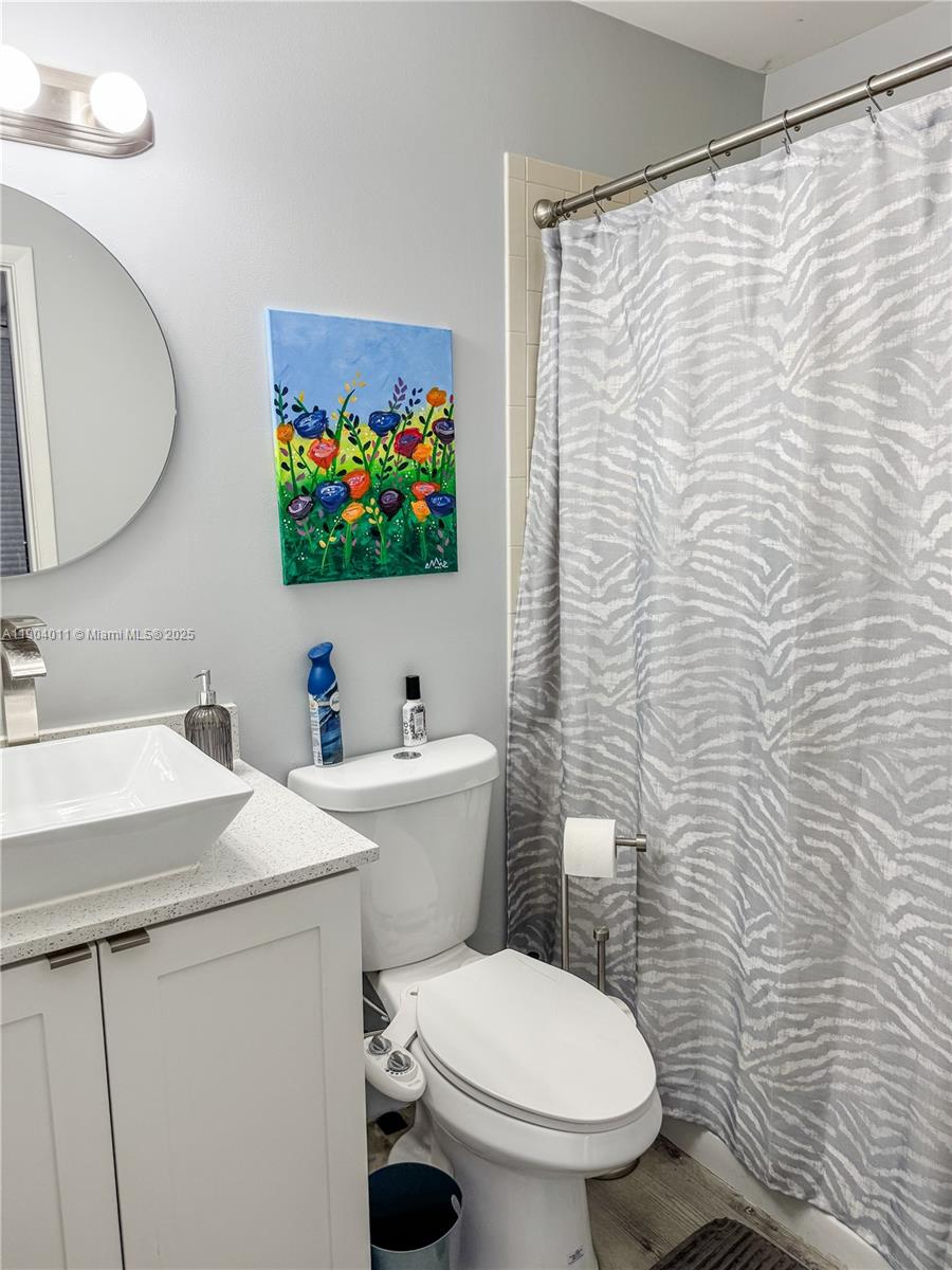 841 Northeast 207th Lane, Unit 3204 Miami, FL 33179 - Photo 15 of 37 a bathroom with a toilet a sink and a mirror