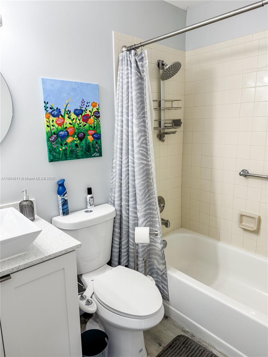 841 Northeast 207th Lane, Unit 3204 Miami, FL 33179 - Photo 16 of 37 a bathroom with a sink a toilet and a bathtub with a bookshelf