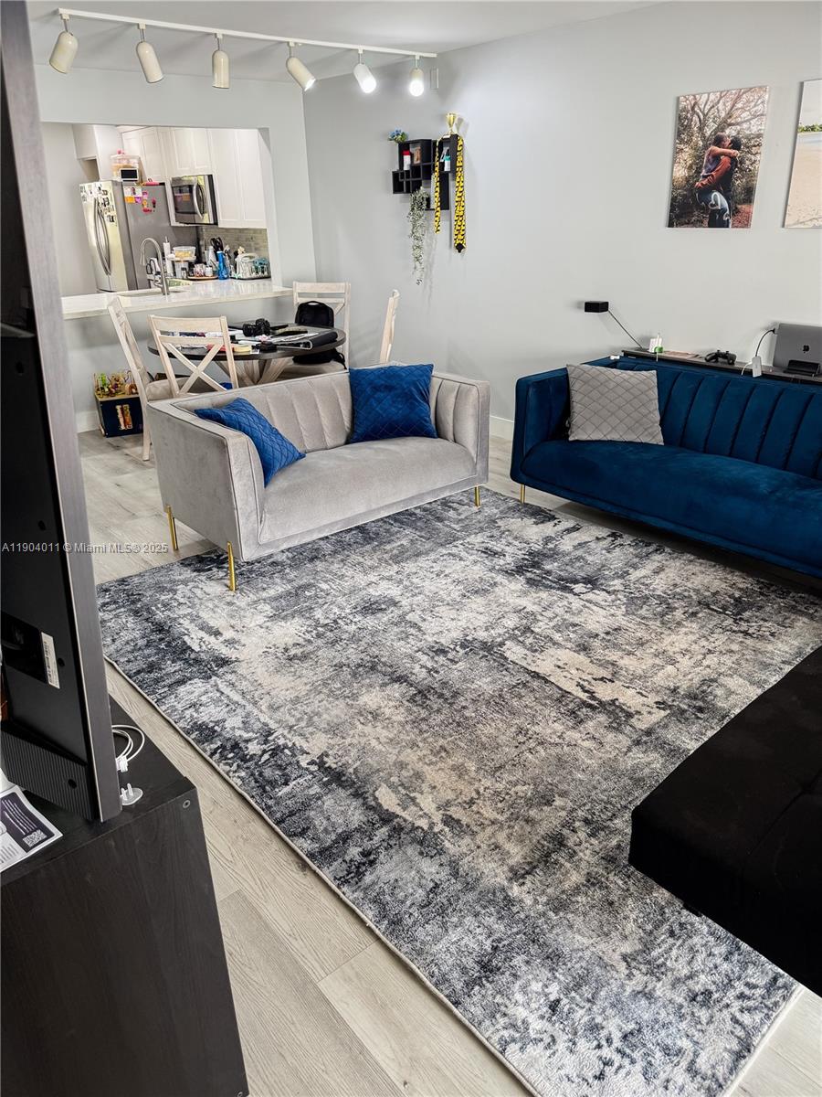841 Northeast 207th Lane, Unit 3204 Miami, FL 33179 - Photo 23 of 37 a living room with kitchen island furniture and a kitchen view