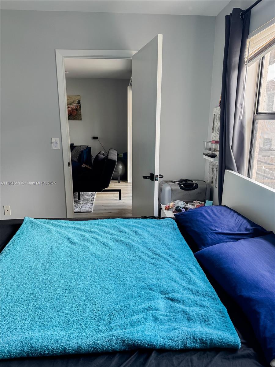 841 Northeast 207th Lane, Unit 3204 Miami, FL 33179 - Photo 25 of 37 a bedroom with a bed and a large mirror