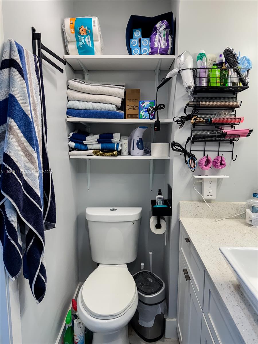841 Northeast 207th Lane, Unit 3204 Miami, FL 33179 - Photo 29 of 37 a bathroom with a toilet a sink and a mirror
