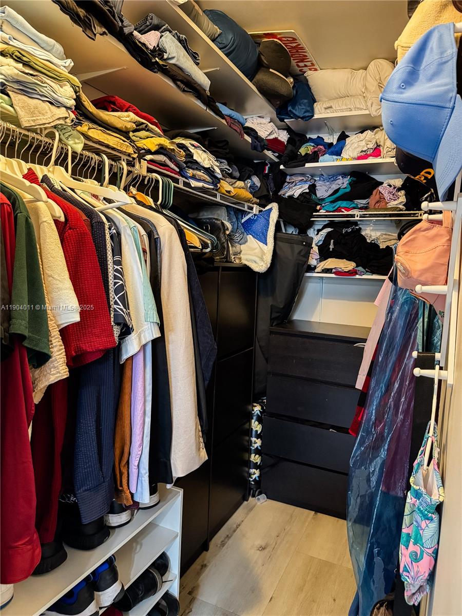 841 Northeast 207th Lane, Unit 3204 Miami, FL 33179 - Photo 30 of 37 a view of walk in closet with clothes and shoes