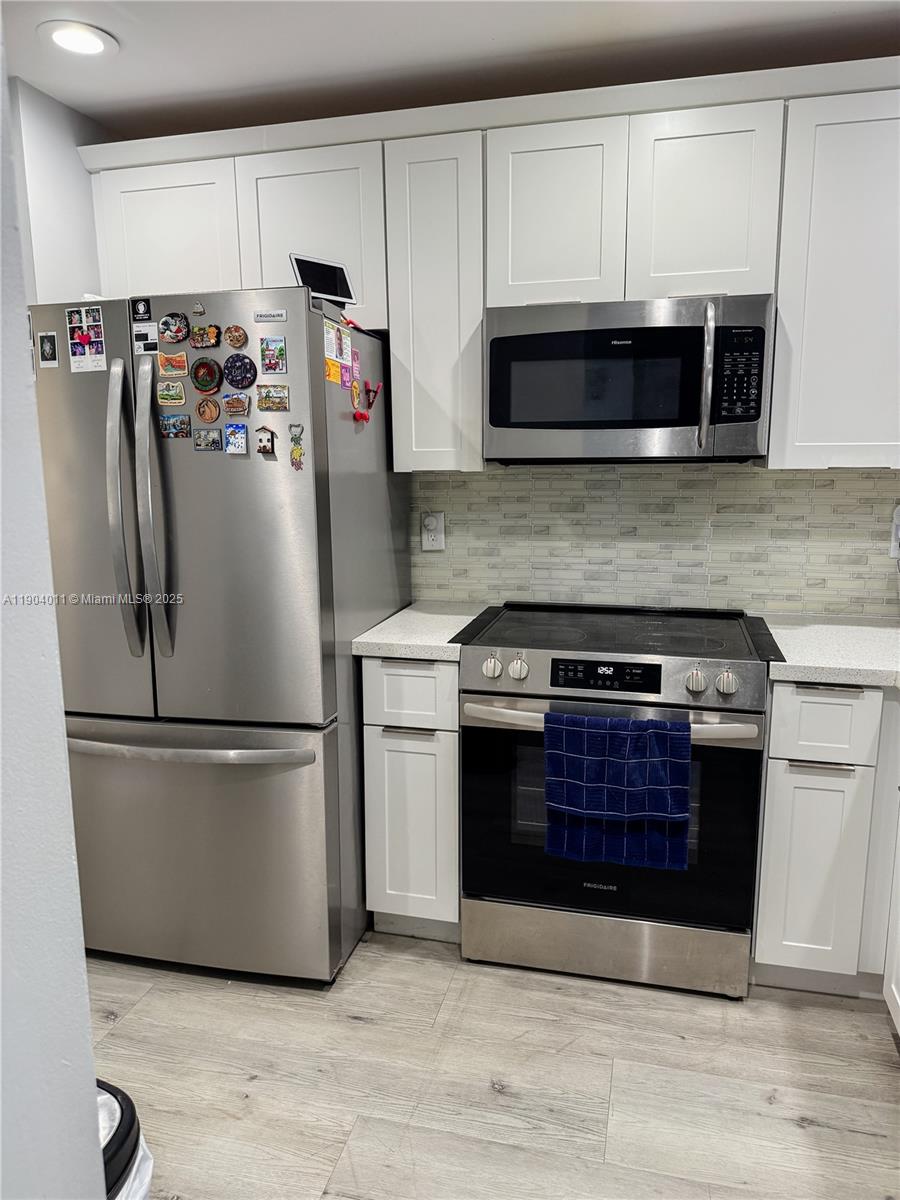 841 Northeast 207th Lane, Unit 3204 Miami, FL 33179 - Photo 3 of 37 a kitchen with stainless steel appliances granite countertop a refrigerator stove and microwave