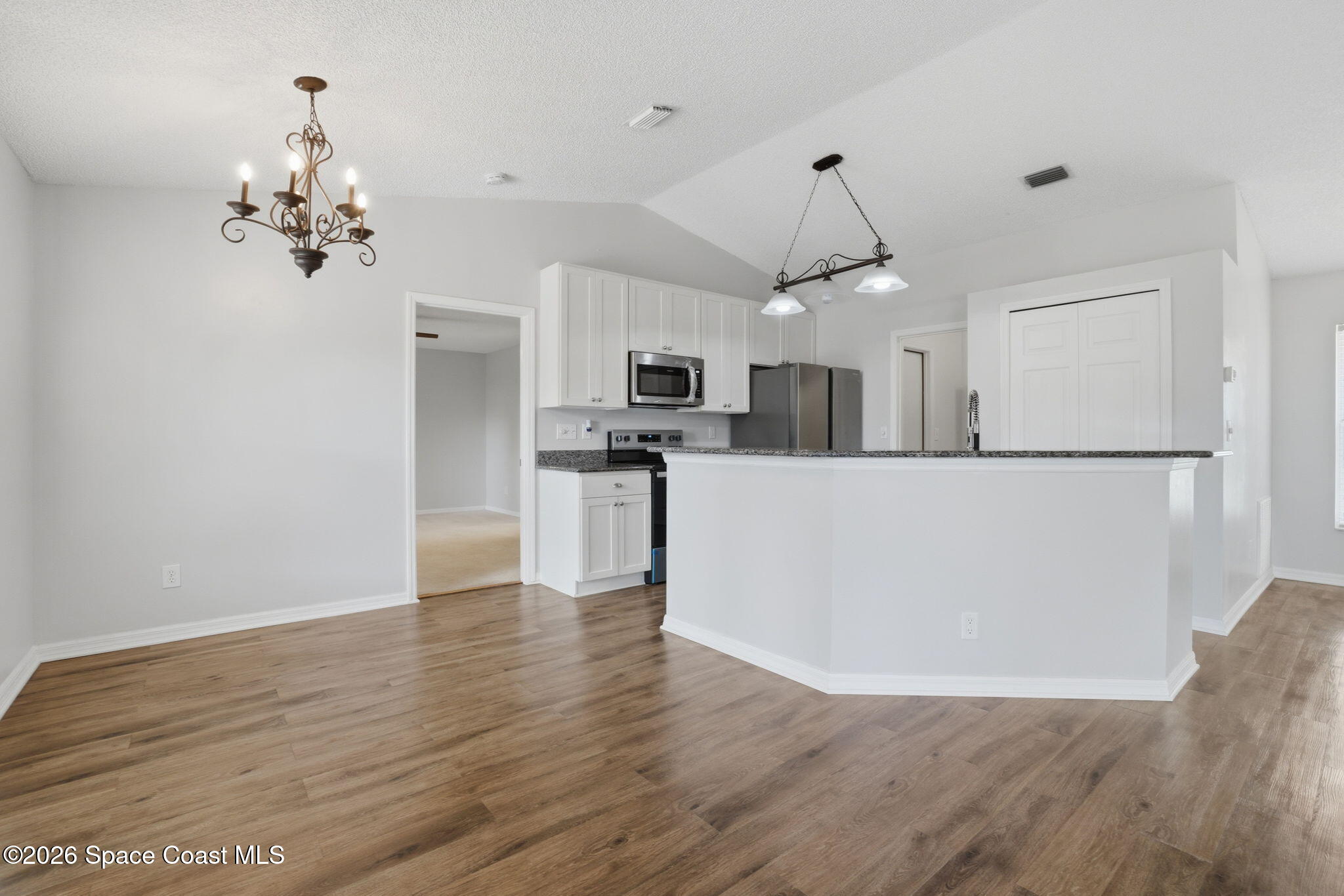 2005 Lansing Street Melbourne, FL 32935 - Photo 11 of 47 a view of a kitchen with wooden floor and stainless steel appliances