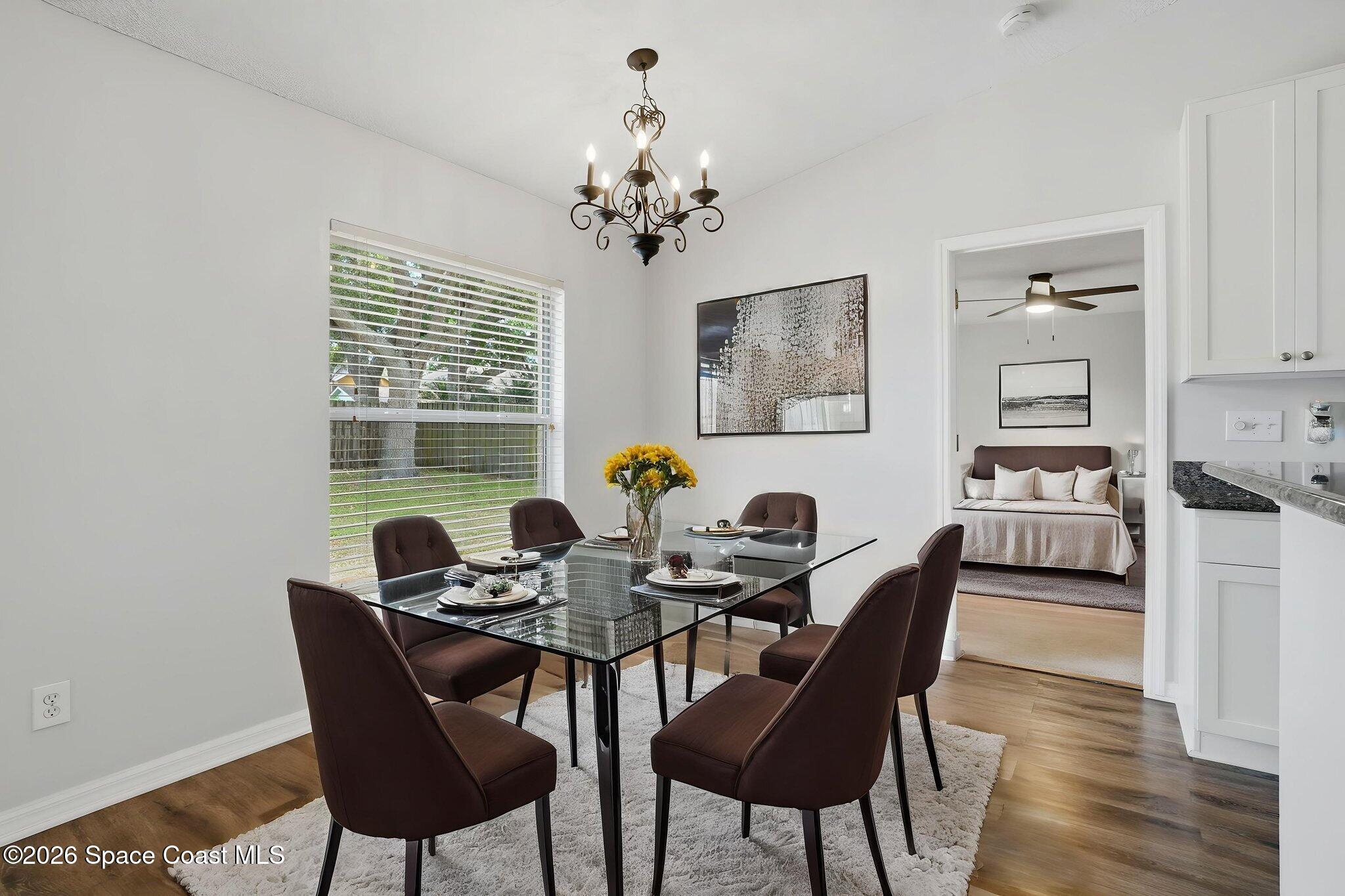 2005 Lansing Street Melbourne, FL 32935 - Photo 13 of 47 a dining room with furniture a rug and a chandelier