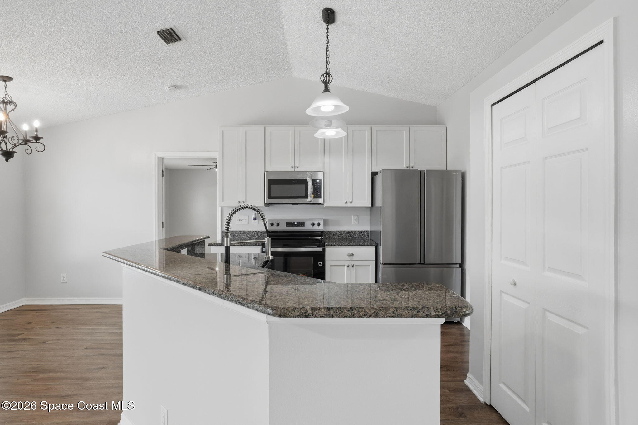 2005 Lansing Street Melbourne, FL 32935 - Photo 17 of 47 a kitchen with granite countertop a refrigerator a stove a sink a center island a stove and cabinets