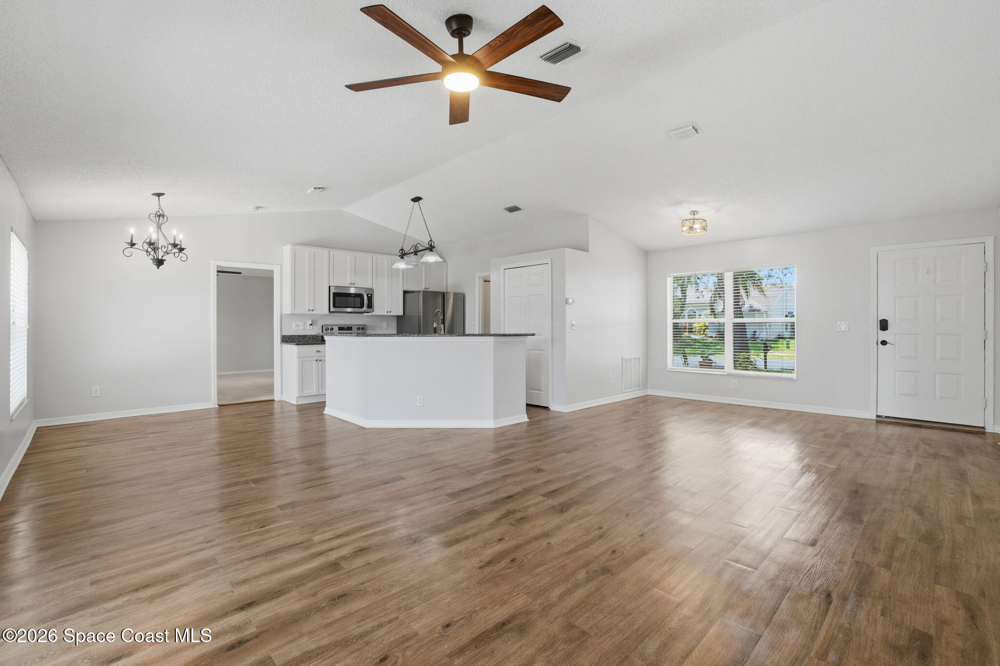 2005 Lansing Street Melbourne, FL 32935 - Photo 3 of 47 a view of a kitchen with wooden floor and a ceiling fan