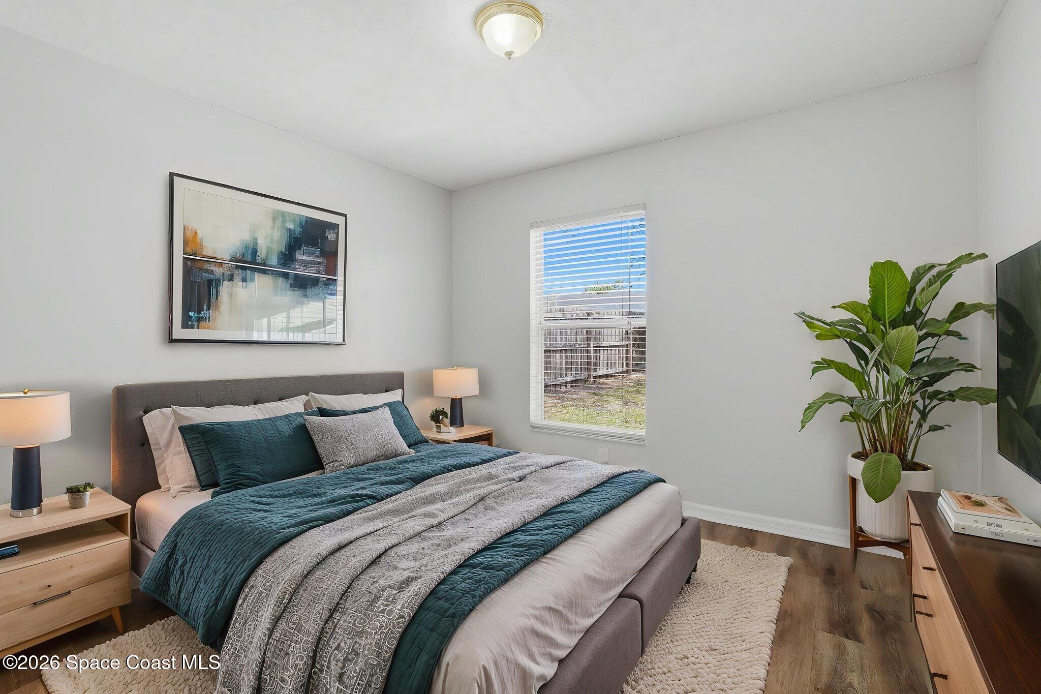 2005 Lansing Street Melbourne, FL 32935 - Photo 32 of 47 a bedroom with bed and a potted plant