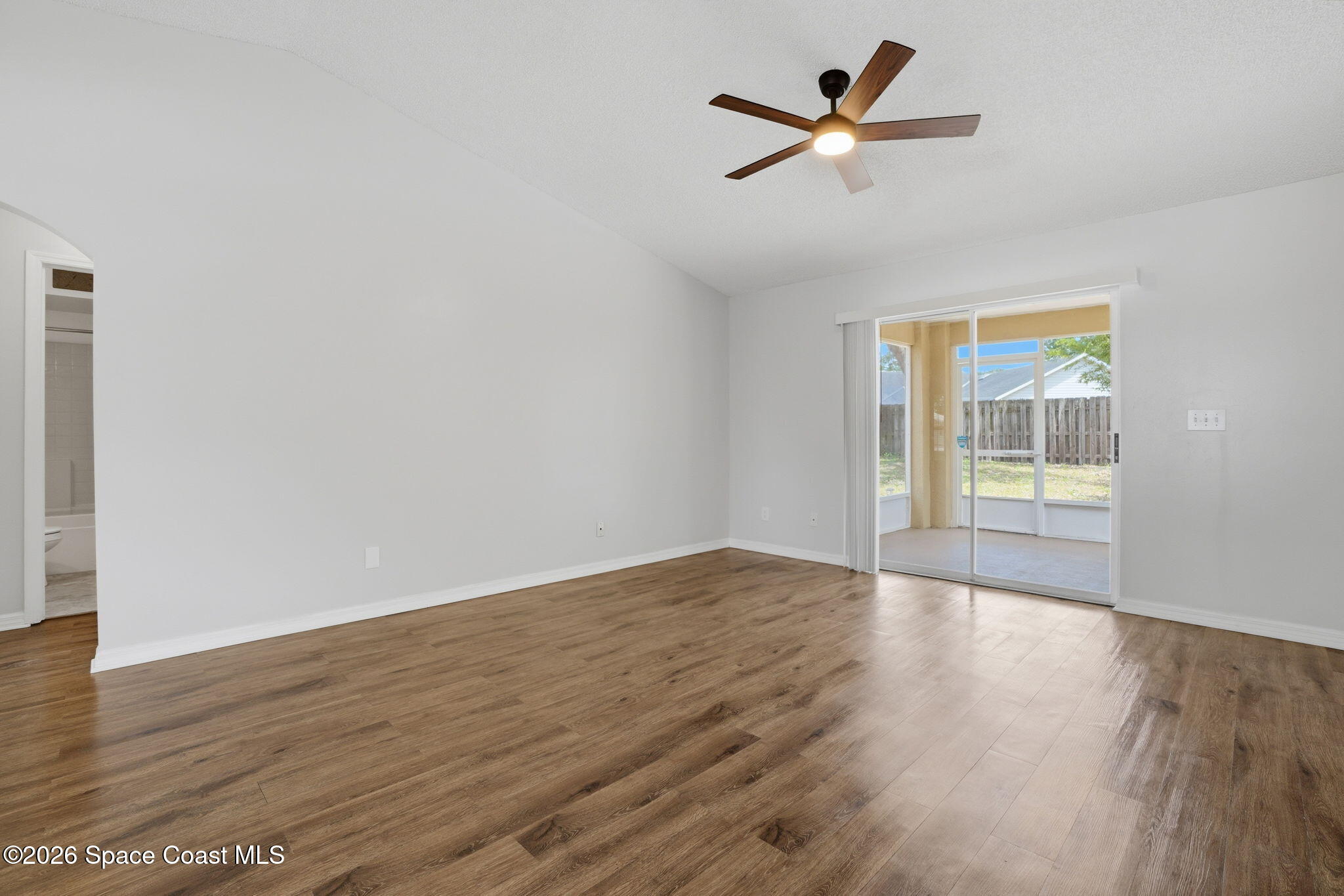 2005 Lansing Street Melbourne, FL 32935 - Photo 4 of 47 an empty room with wooden floor and ceiling fan