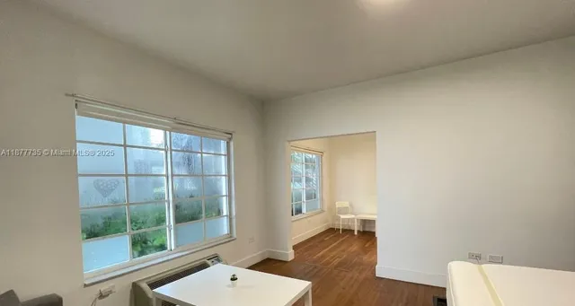 a living room with a wooden floor and a window