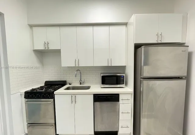 a white refrigerator freezer and a stove sitting inside of a kitchen