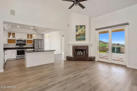 a view of an empty room with a kitchen and a fireplace