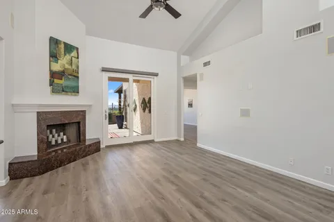 a view of an empty room with window and fire place