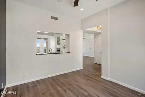 an empty room with wooden floor and mirror