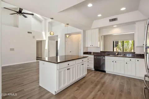 a kitchen with granite countertop a sink and cabinets