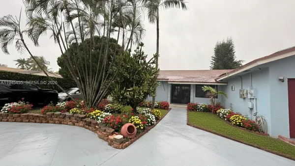 a view of a house with a yard and potted plants