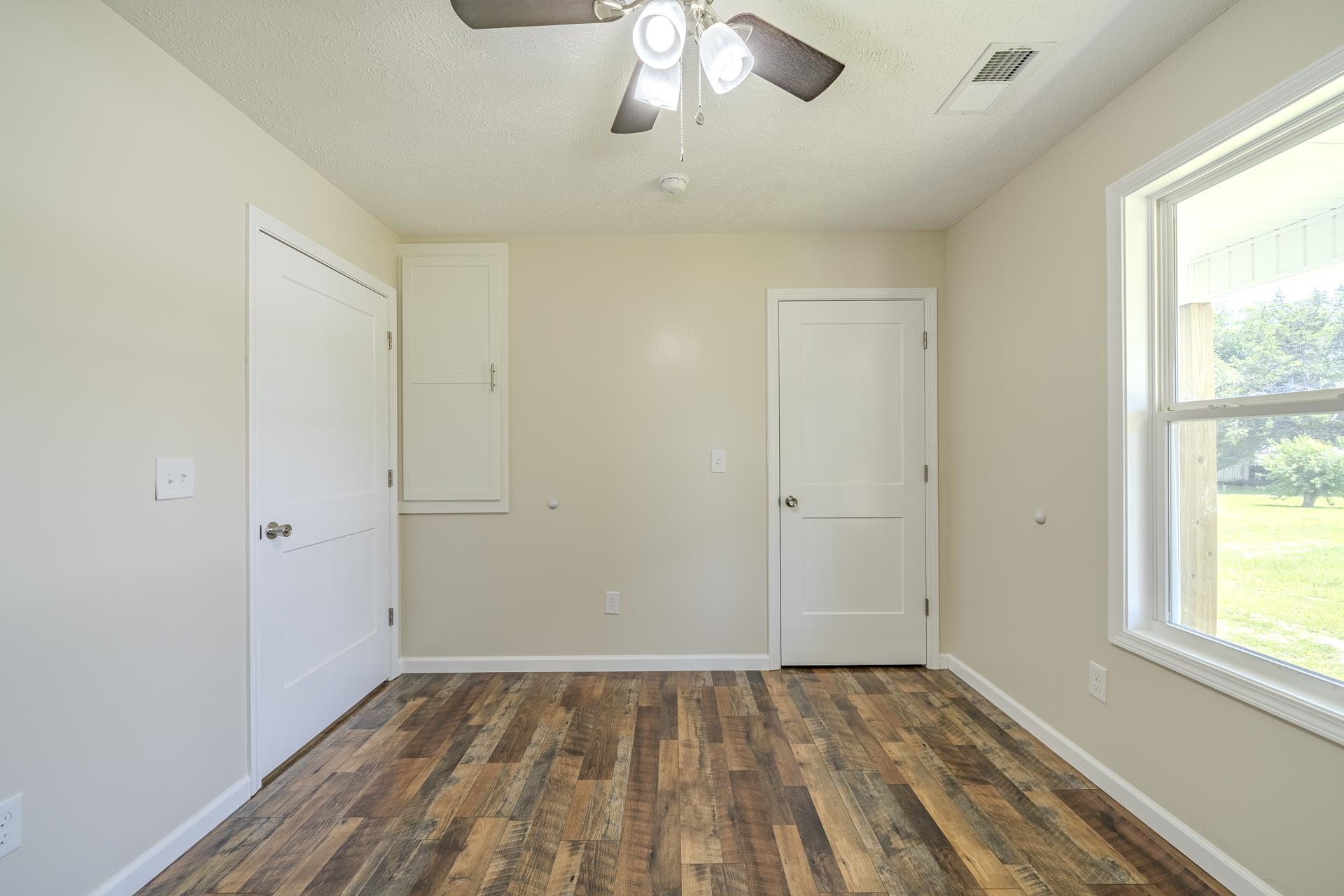 231 Clausel Lane Adamsville, TN 38310 - Photo 18 of 32 a view of an empty room with wooden floor and a window