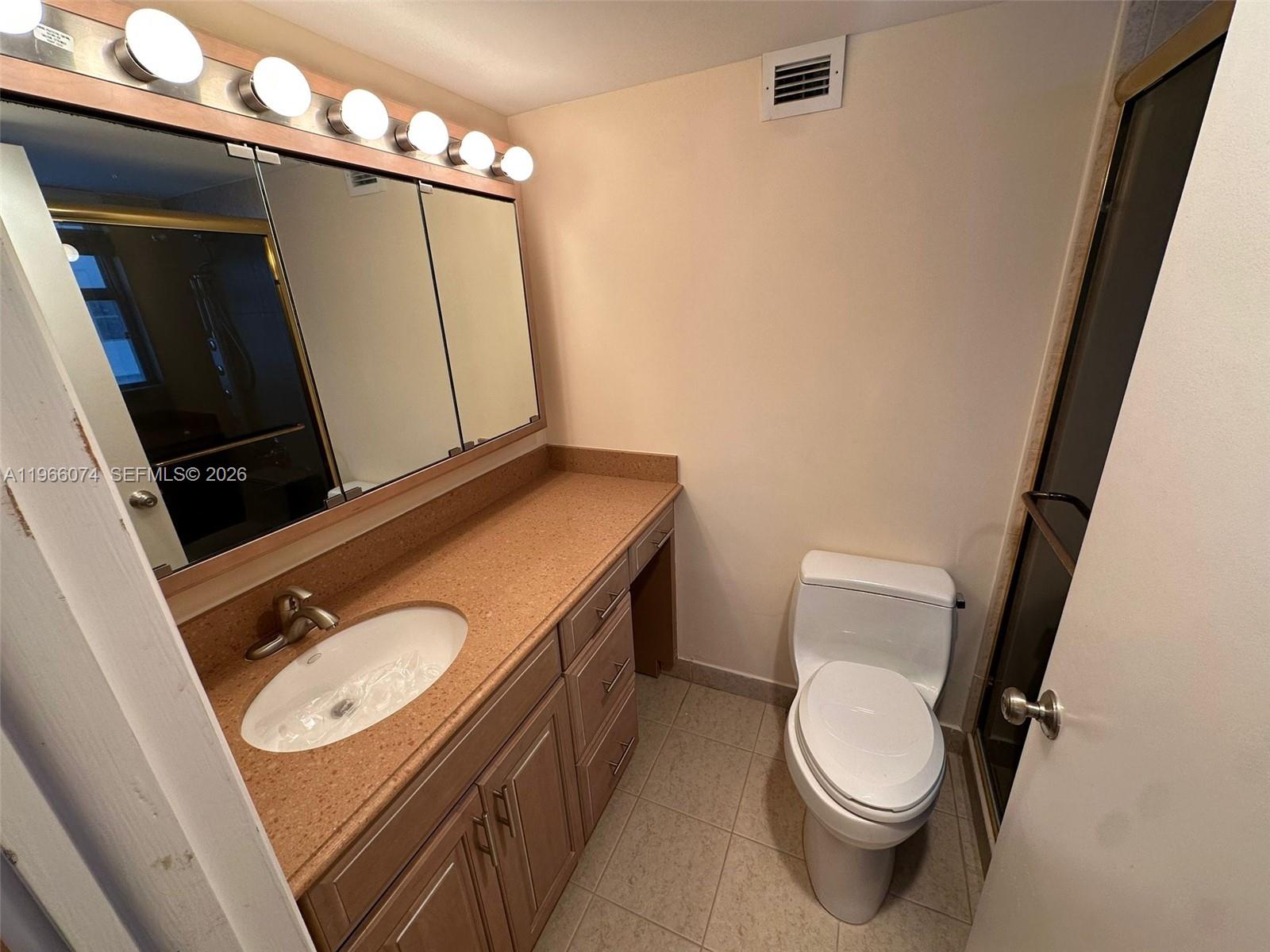 6039 Collins Avenue, Unit 1625 Miami Beach, FL 33140 - Photo 17 of 45 a bathroom with a sink a mirror and toilet