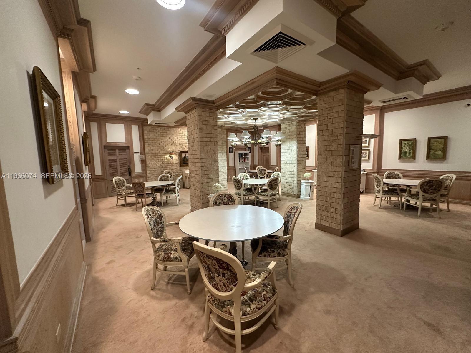 6039 Collins Avenue, Unit 1625 Miami Beach, FL 33140 - Photo 38 of 45 a dining room with furniture and a chandelier