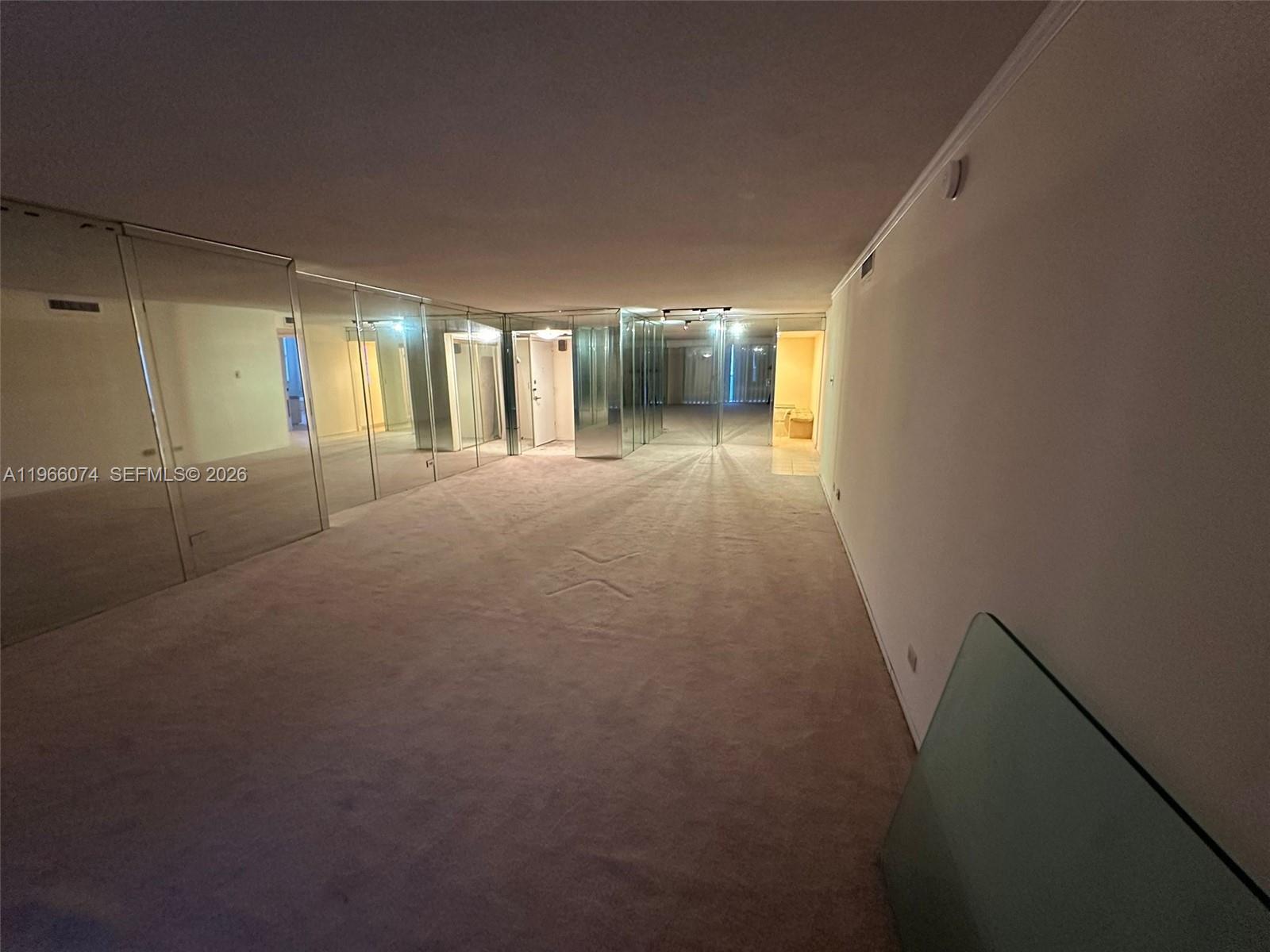 6039 Collins Avenue, Unit 1625 Miami Beach, FL 33140 - Photo 6 of 45 a view of empty room with floor to ceiling window and ceiling fan