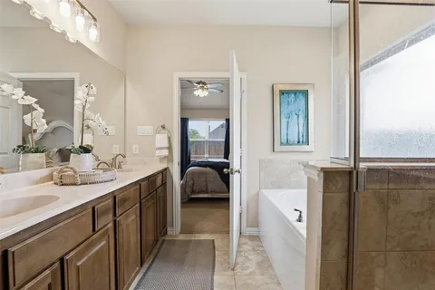 a en suite bathroom with a double vanity sink a mirror and a shower