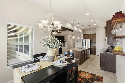 a dining room with wooden floor and stainless steel appliances