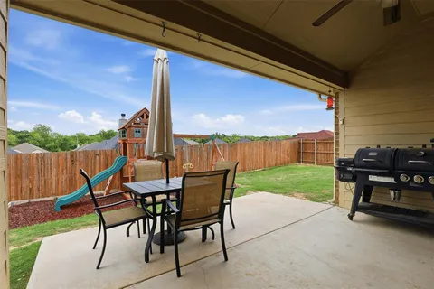 a view of a chairs and table in patio with a yard