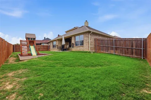 a view of a house with a yard and sitting area
