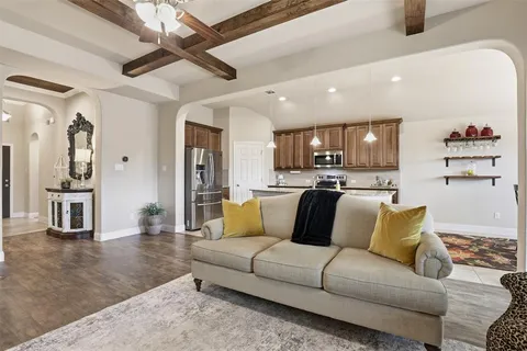 a view of living room kitchen with stainless steel appliances kitchen island granite countertop furniture and a view of kitchen