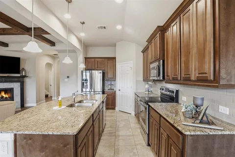 a kitchen with stainless steel appliances granite countertop a sink stove and cabinets
