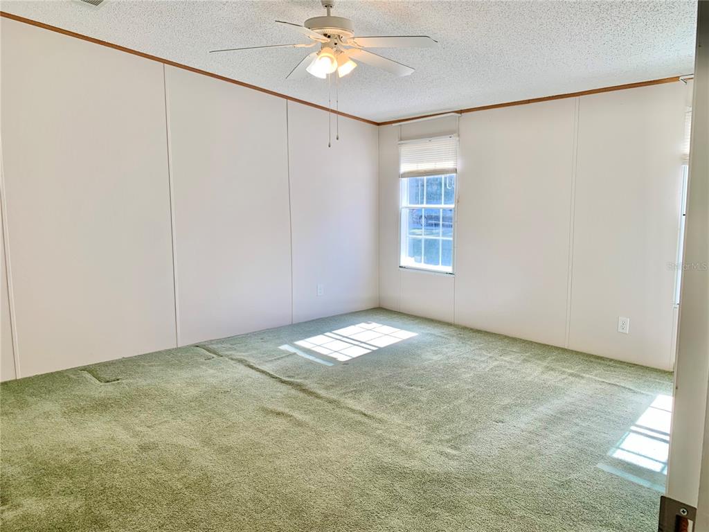 12752 Southeast 9th Place Gainesville, FL 32641 - Photo 21 of 53 an empty room with a ceiling fan and window