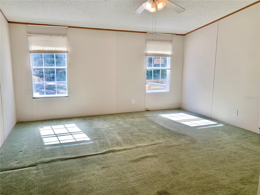 12752 Southeast 9th Place Gainesville, FL 32641 - Photo 22 of 53 an empty room with windows and chandelier fan