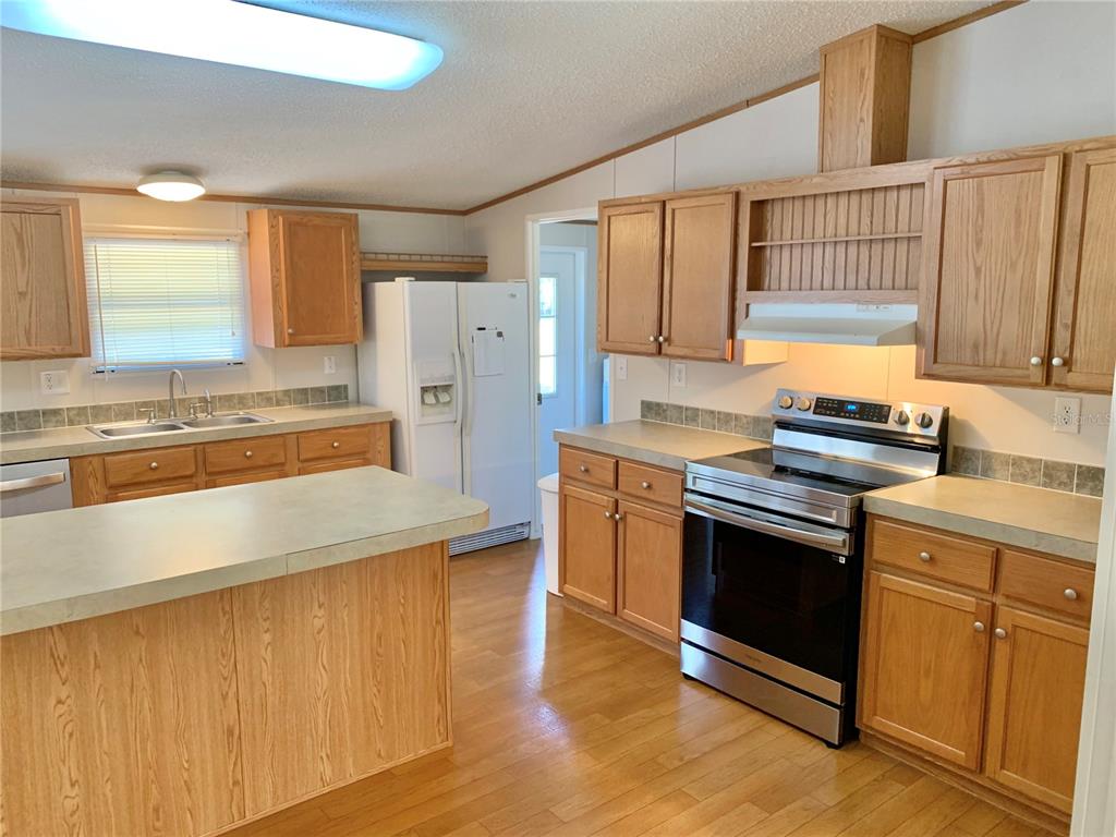 12752 Southeast 9th Place Gainesville, FL 32641 - Photo 7 of 53 a kitchen with stainless steel appliances granite countertop a stove a sink and a refrigerator