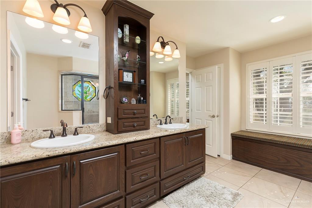 605 South Hutto Road Donna, TX 78537 - Photo 12 of 45 The primary bathroom features double sinks, granite counter tops and plenty of storage space. The built-in bench offers even more storage space. In addition, it is the perfect spot to stage your outfit of the day.