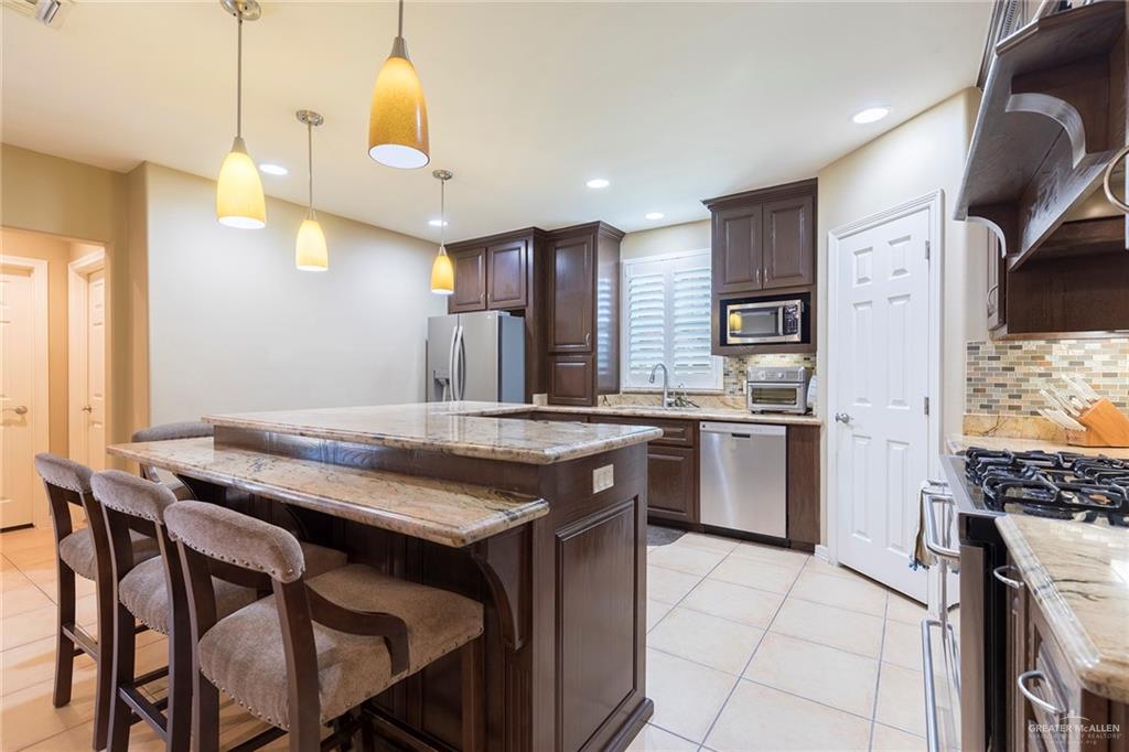 605 South Hutto Road Donna, TX 78537 - Photo 10 of 45 A large laundry room and half bathroom sit adjacent to the kitchen.