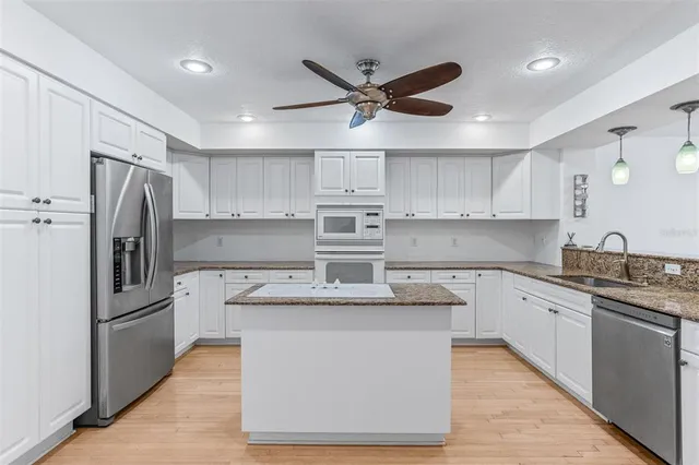 a kitchen with stainless steel appliances granite countertop a sink and cabinets