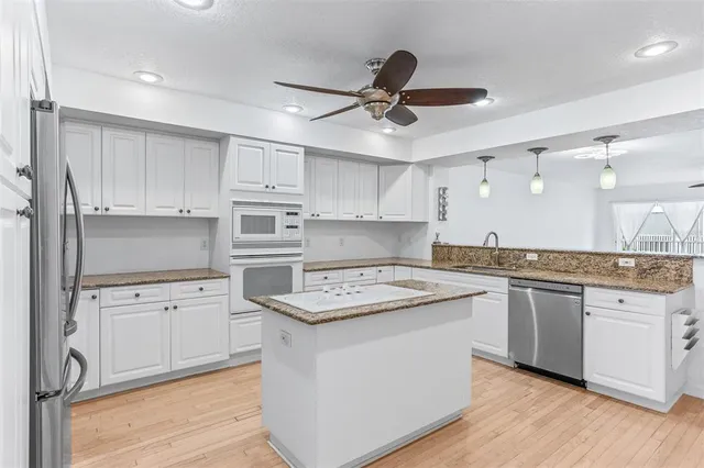 a view of a kitchen with a refrigerator and a stove top oven